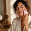 Donna che applica la routine di skincare con microcorrente viso — Art Design Academy